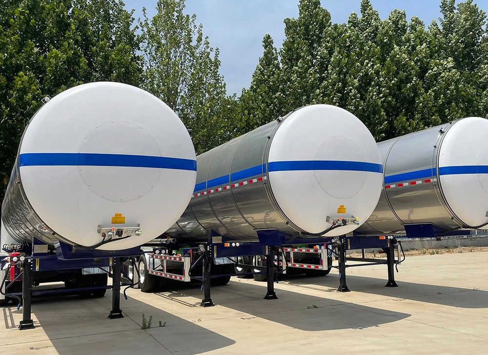 Triple-axle chemical trailer showing stainless steel tank and BPW axles