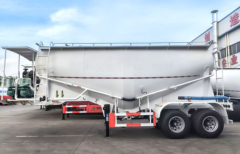 V-shaped cement powder trailer showing discharge valve and dual manholes