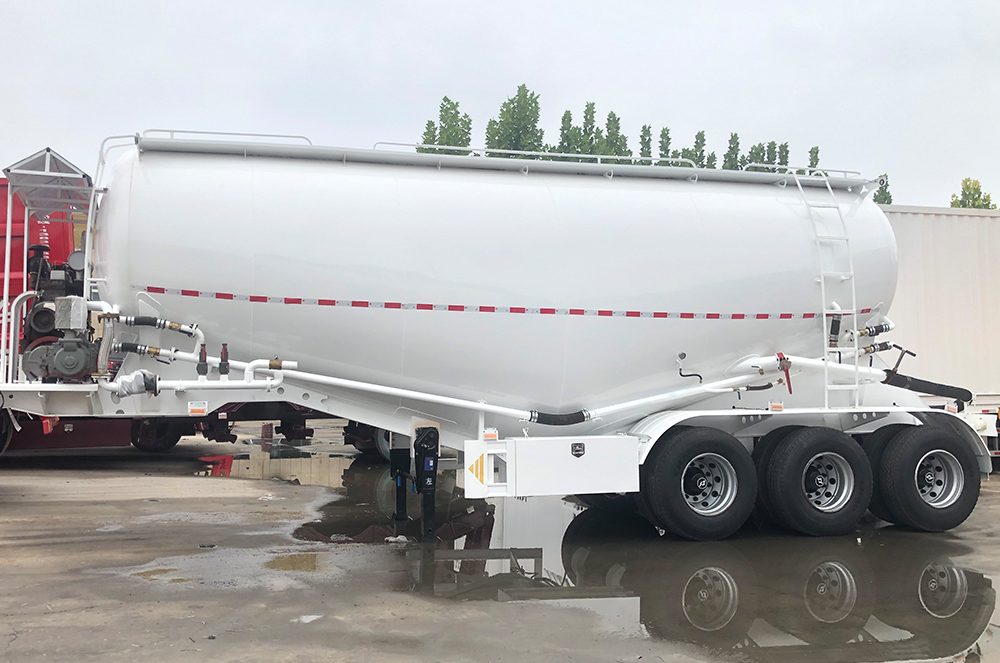 Bulk cement transport trailer showing V-type tank and rear discharge piping