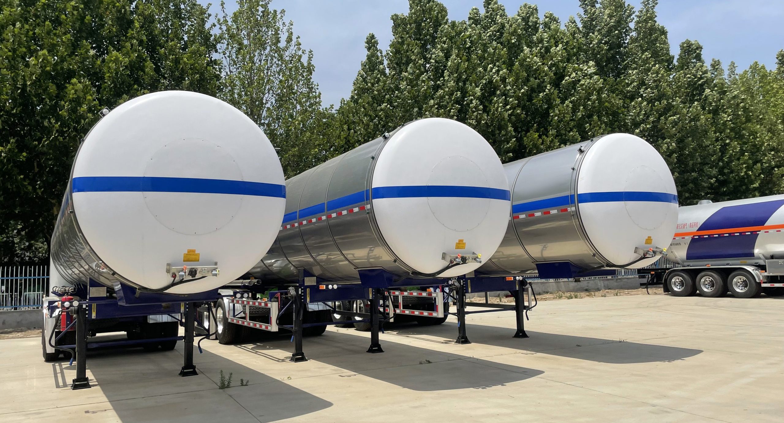 Triple-axle chemical trailer showing stainless steel tank and BPW axles